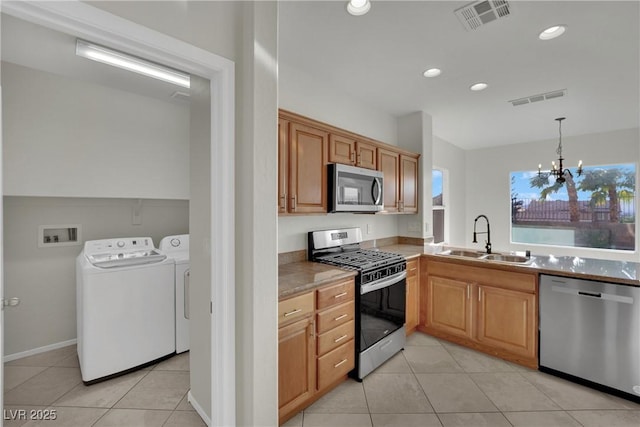 2749 Invermark St, Henderson, NV 89044 - kitchen featuring stainless steel appliances, washer and dryer, light tile patterned floors, a chandelier, and recessed lighting