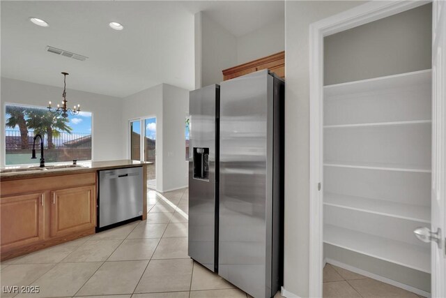 2749 Invermark St, Henderson, NV 89044 - kitchen featuring appliances with stainless steel finishes, light tile patterned floors, a chandelier, hanging light fixtures, and recessed lighting
