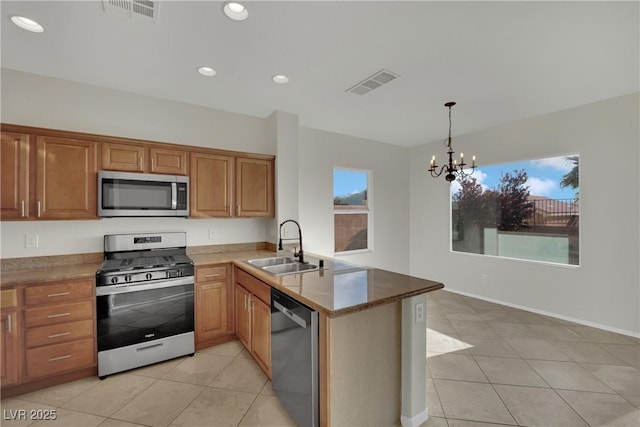 2749 Invermark St, Henderson, NV 89044 - kitchen with appliances with stainless steel finishes, a peninsula, a chandelier, light tile patterned floors, and plenty of natural light