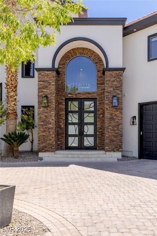 9501 Balatta Canyon Ct, Las Vegas, NV 89144 - view of exterior entry with stucco siding, french doors, and stone siding