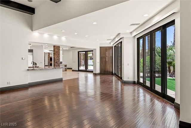 9501 Balatta Canyon Ct, Las Vegas, NV 89144 - unfurnished living room featuring baseboards, visible vents, plenty of natural light, and wood finished floors