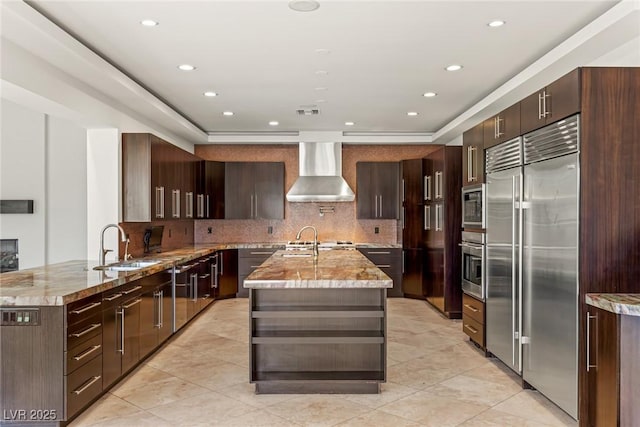 9501 Balatta Canyon Ct, Las Vegas, NV 89144 - kitchen with built in appliances, light stone countertops, a sink, backsplash, and wall chimney range hood