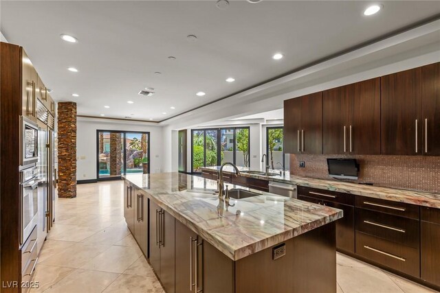 9501 Balatta Canyon Ct, Las Vegas, NV 89144 - kitchen with a sink, a center island with sink, appliances with stainless steel finishes, decorative backsplash, and recessed lighting