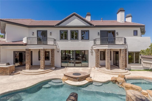 9501 Balatta Canyon Ct, Las Vegas, NV 89144 - back of property featuring a balcony, a patio, a fire pit, and a chimney