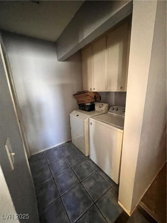 washroom featuring cabinet space, dark tile patterned flooring, and washer and dryer