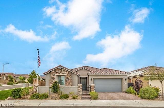 8257 Skye Peak St, Las Vegas, NV 89166 - view of front facade featuring a tiled roof, decorative driveway, stucco siding, stone siding, and an attached garage