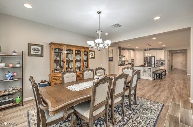 8257 Skye Peak St, Las Vegas, NV 89166 - dining room with a chandelier, light wood finished floors, recessed lighting, and baseboards