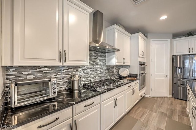 8257 Skye Peak St, Las Vegas, NV 89166 - kitchen with appliances with stainless steel finishes, wall chimney exhaust hood, white cabinets, and recessed lighting
