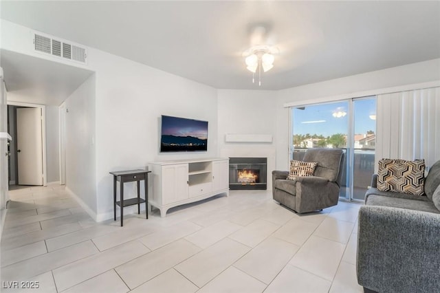 3066 Tarpon Dr Unit 204, Las Vegas, NV 89120 - living room with visible vents, a ceiling fan, light tile patterned floors, baseboards, and a glass covered fireplace