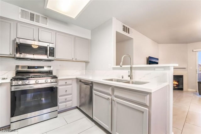3066 Tarpon Dr Unit 204, Las Vegas, NV 89120 - kitchen featuring a peninsula, light tile patterned floors, a sink, stainless steel appliances, and visible vents