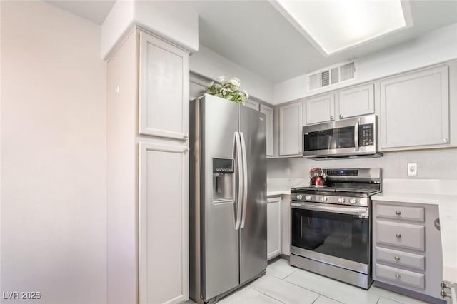 3066 Tarpon Dr Unit 204, Las Vegas, NV 89120 - kitchen featuring gray cabinetry, light countertops, visible vents, and appliances with stainless steel finishes