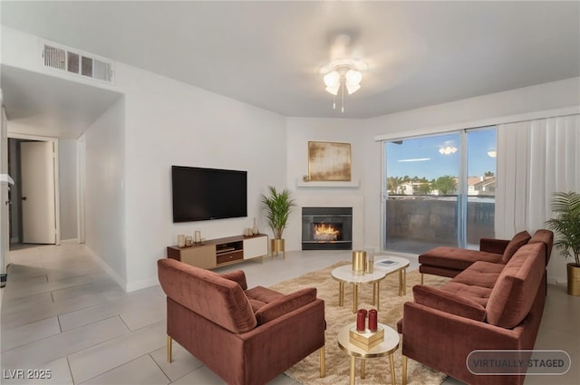3066 Tarpon Dr Unit 204, Las Vegas, NV 89120 - living room featuring ceiling fan, light tile patterned floors, a glass covered fireplace, and baseboards