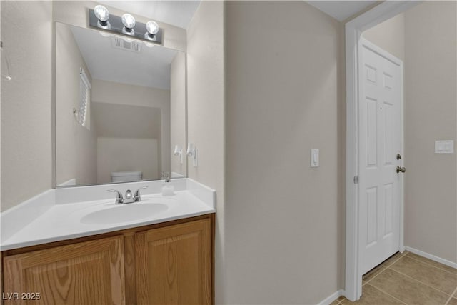 half bathroom with toilet, vanity, visible vents, tile patterned floors, and baseboards