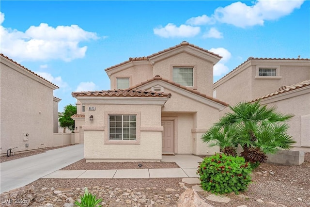 mediterranean / spanish house featuring concrete driveway, stucco siding, and a tiled roof