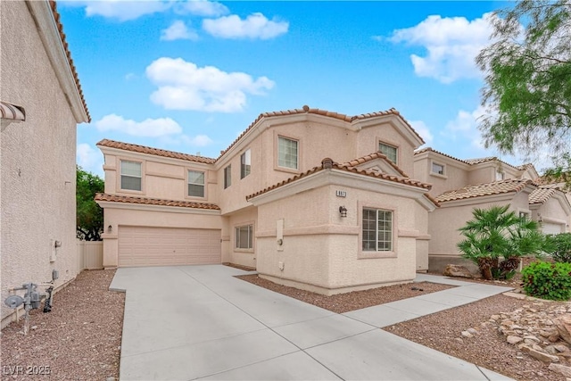 mediterranean / spanish-style home with a tile roof, concrete driveway, an attached garage, and stucco siding
