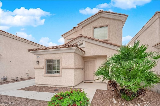 mediterranean / spanish house with stucco siding and a tile roof