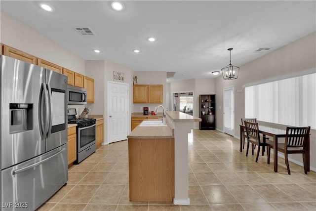 kitchen featuring stainless steel appliances, light tile patterned floors, visible vents, a sink, and light countertops