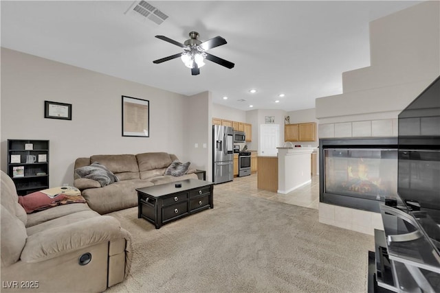 living room with light tile patterned floors, visible vents, ceiling fan, light colored carpet, and recessed lighting