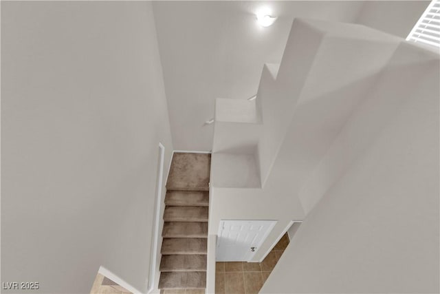 stairs featuring baseboards and tile patterned floors