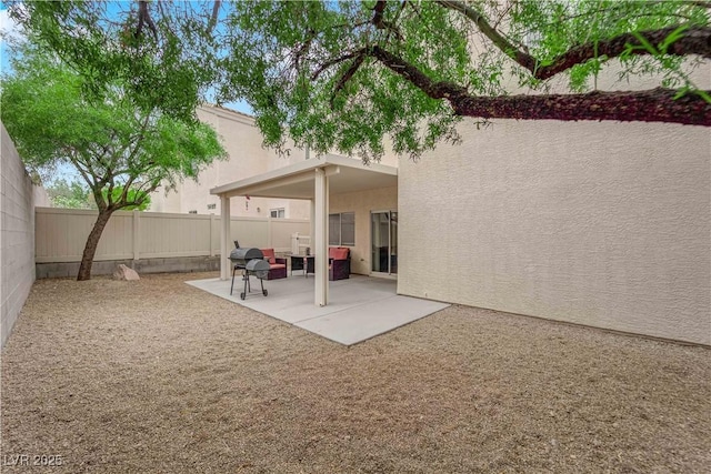 back of property with a fenced backyard, a patio area, and stucco siding