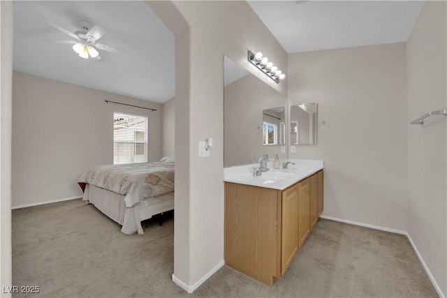 bathroom with ceiling fan, connected bathroom, and baseboards