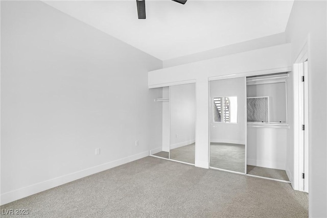 unfurnished bedroom with two closets, baseboards, carpet, and ceiling fan