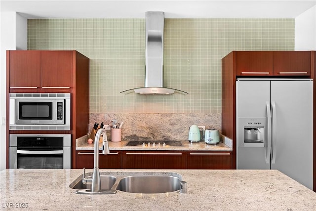 kitchen with a sink, wall chimney exhaust hood, backsplash, light stone countertops, and appliances with stainless steel finishes