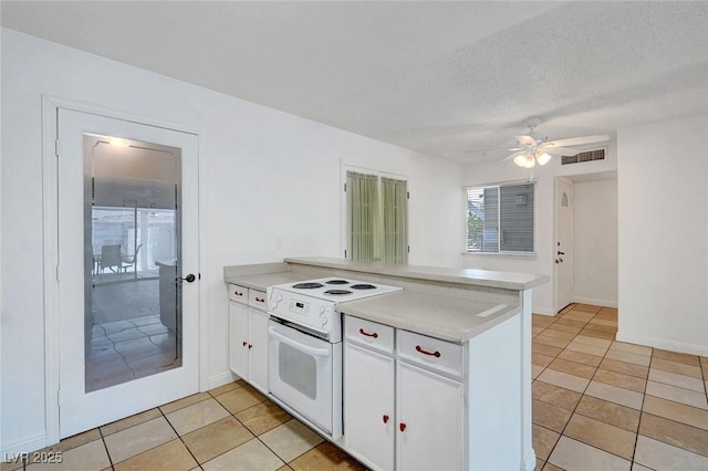 kitchen featuring white electric range oven, a peninsula, light tile patterned floors, a ceiling fan, and white cabinets