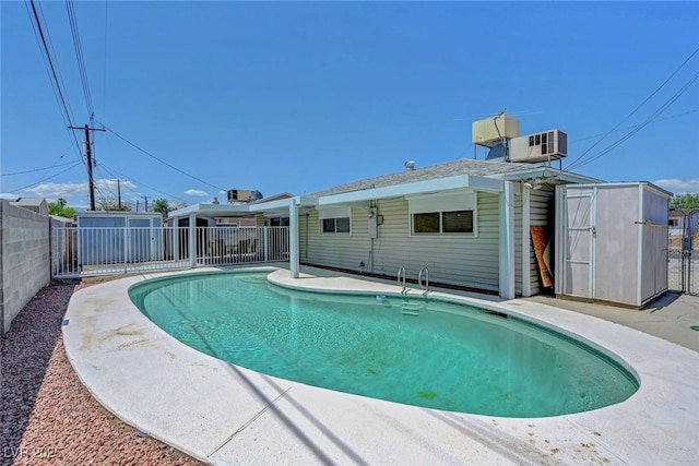 view of swimming pool with a storage shed, fence, and an outdoor structure