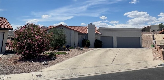 view of front of home with a tiled roof, stucco siding, a garage, and concrete driveway