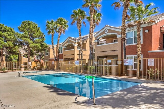 community pool featuring a patio area and fence