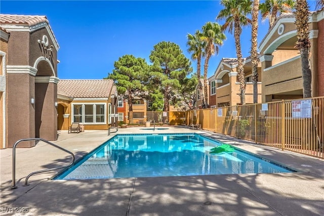 community pool with fence and a patio