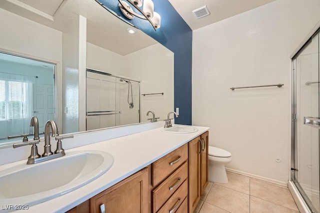 bathroom featuring a sink, tile patterned flooring, double vanity, and visible vents