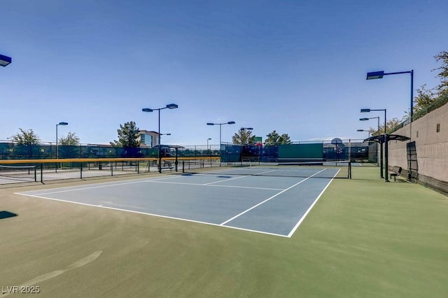 view of tennis court featuring fence and community basketball court