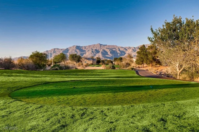 view of home's community featuring a mountain view, a lawn, and golf course view