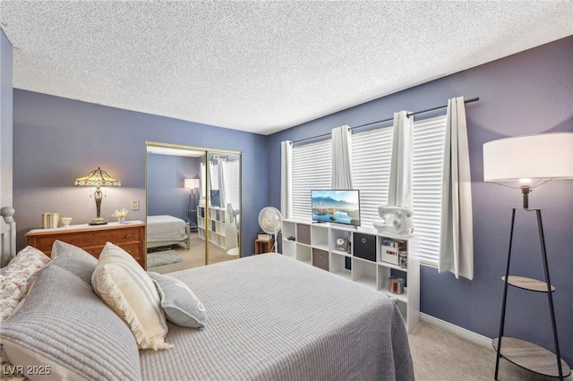 carpeted bedroom with a closet, baseboards, and a textured ceiling