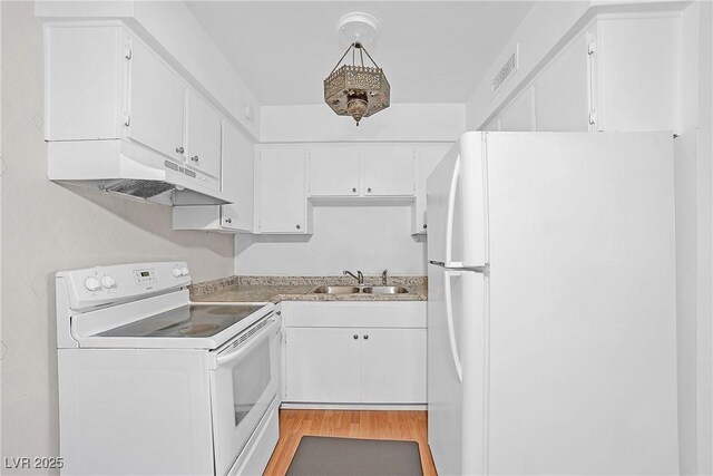 kitchen with white appliances, a sink, under cabinet range hood, light wood-style flooring, and white cabinetry
