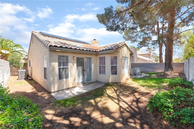 7617 Sea Cliff Way, Las Vegas, NV 89128 - back of property featuring a tiled roof, stucco siding, a fenced backyard, central AC unit, and a chimney