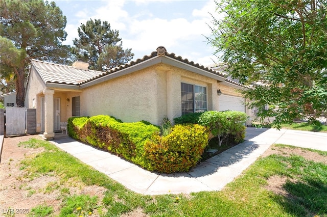7617 Sea Cliff Way, Las Vegas, NV 89128 - view of property exterior with stucco siding, a tiled roof, a chimney, fence, and an attached garage