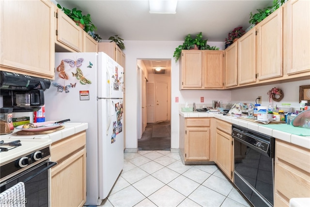 7617 Sea Cliff Way, Las Vegas, NV 89128 - kitchen with black dishwasher, light brown cabinets, freestanding refrigerator, tile countertops, and gas stove