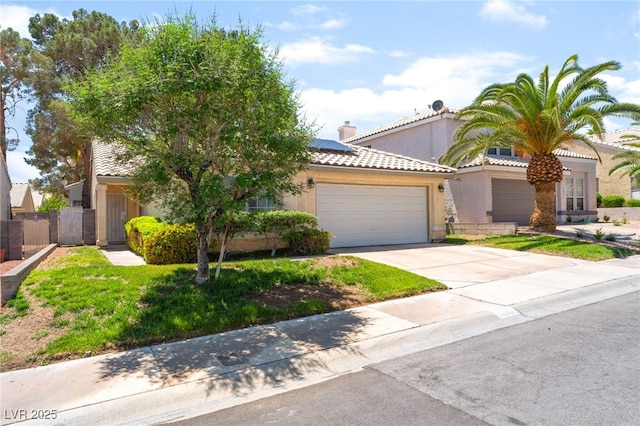 7617 Sea Cliff Way, Las Vegas, NV 89128 - view of front of home featuring a garage, solar panels, driveway, stucco siding, and a tiled roof