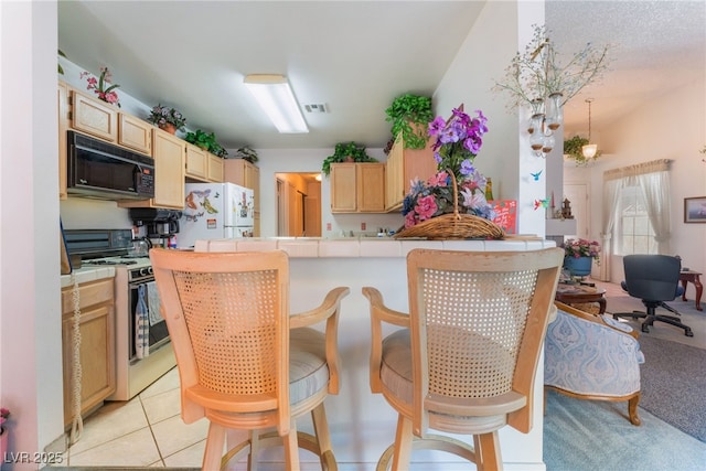 7617 Sea Cliff Way, Las Vegas, NV 89128 - kitchen featuring white appliances, tile counters, light brown cabinets, a peninsula, and a breakfast bar