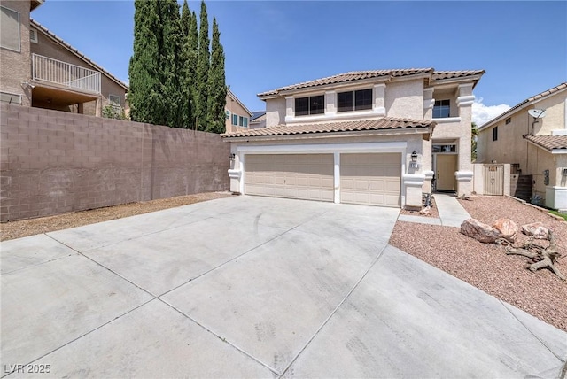 view of front of house with a tiled roof, fence, a garage, stucco siding, and concrete driveway