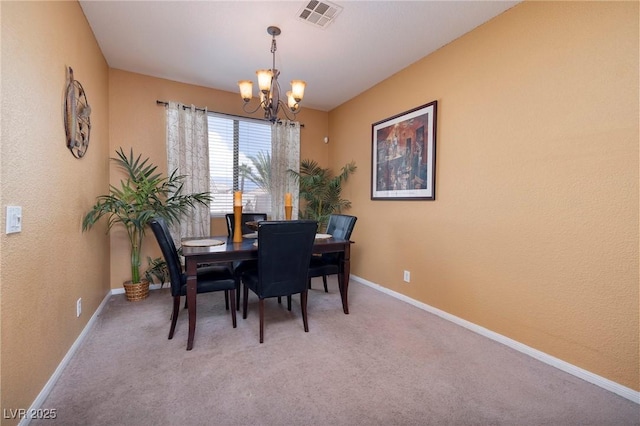 dining space featuring baseboards, a chandelier, visible vents, and carpet