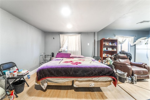 1708 Weeping Willow Ln, Las Vegas, NV 89104 - bedroom featuring wood finished floors, multiple windows, and freestanding refrigerator
