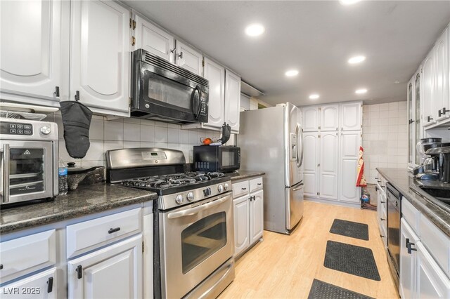 1708 Weeping Willow Ln, Las Vegas, NV 89104 - kitchen with stainless steel appliances, decorative backsplash, dark countertops, light wood-style flooring, and white cabinets
