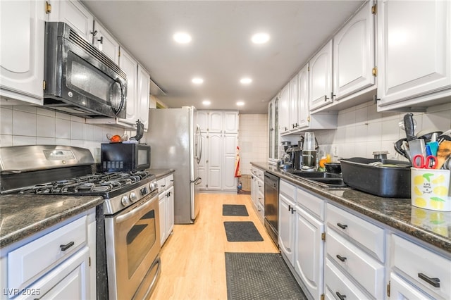 1708 Weeping Willow Ln, Las Vegas, NV 89104 - kitchen with stainless steel appliances, tasteful backsplash, dark countertops, white cabinetry, and recessed lighting