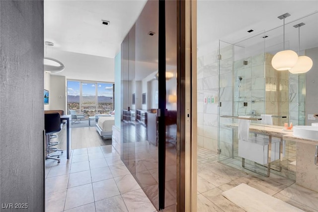 bathroom with a stall shower and a sink