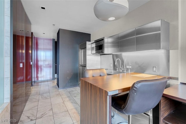 kitchen with stainless steel microwave, marble finish floor, visible vents, light countertops, and modern cabinets