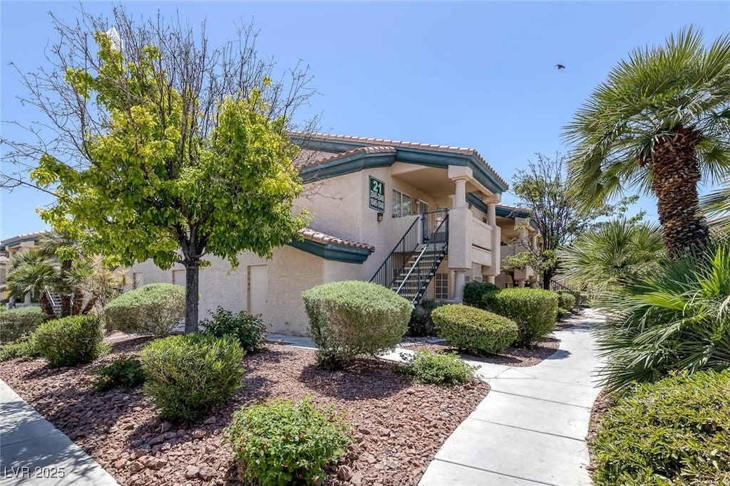 8410 Eldora Ave Unit 1045, Las Vegas, NV 89117 - view of side of property featuring stairs, a tiled roof, and stucco siding